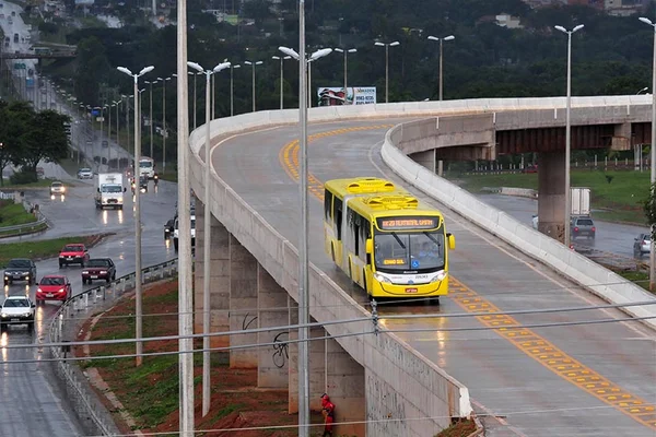 Ônibus amarelo BRT passando em viaduto cercado de outras pistas abaixo - Metrópoles