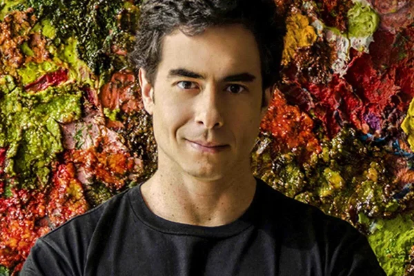 Felipe Folgosi posa, sorridente, com uma camiseta preta - Metrópoles
