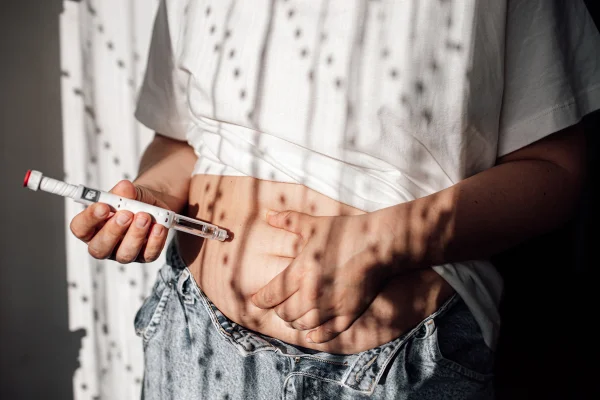 Injeções para perda de peso com Semaglutida. Uma mulher obesa aplica uma injeção hormonal no abdômen com uma seringa de caneta de Wegovy Ozempic gordura no fígado