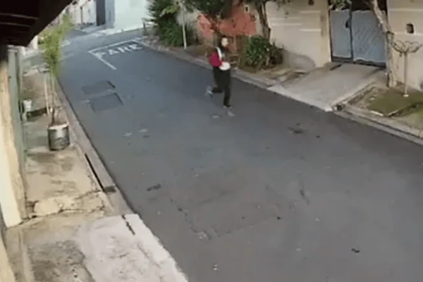Imagem colorida de uma jovem sendo abordada por um criminoso em uma moto - Metrópoles