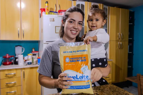 Daniela Gomes Uchoa e a pequena Maria, de 1 ano, beneficiárias do programa Leve Leite, da Prefeitura de São Paulo