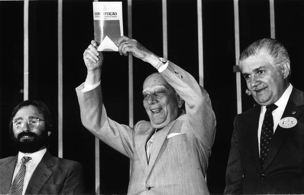 Imagem em preto e branco de Ulysses Guimarães com a Constituição de 1988 - Metrópoles