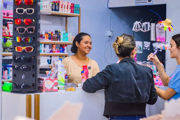 Fotografia colorida mostrando duas mulheres sendo atendidas por outra em loja-Metrópoles