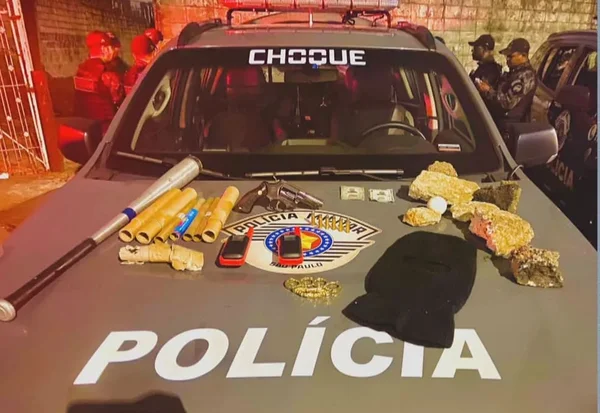 Sobre o capô de uma viatura da Polícia Militar estão um taco de beisebol, seis rojões, dois rádios, um revólver, uma touca e pedras - Metrópoles