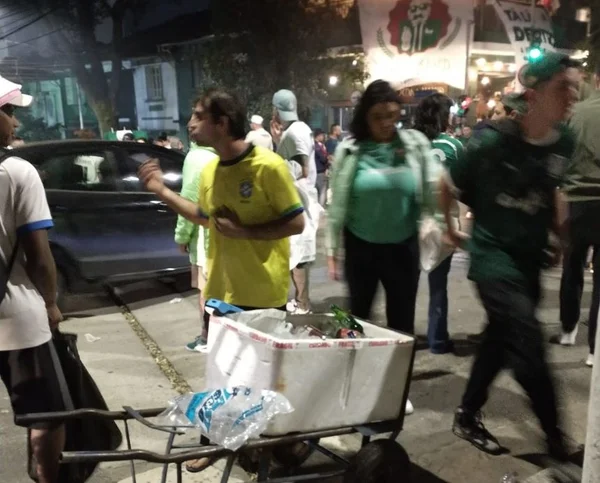 Torcedores do Palmeiras passam por caixa de isopor de ambulante vendendo cerveja em garrafa de vidro ao redor do estádio Allianz Parque - Metrópoles