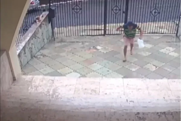 Imagem colorida, zelador entrando no prédio com galão de gasolina-Merópoles