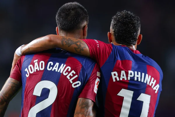 Cancelo e Raphinha abraçados - Metrópoles