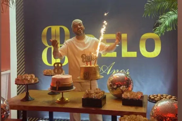 Na imagem colorida, homem aparece atrás de bolo durante festa - Metrópoles