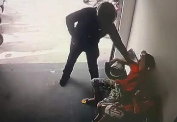 Imagem colorida de homem armado com capacete abordando jovem de camiseta vermelha - Metrópoles