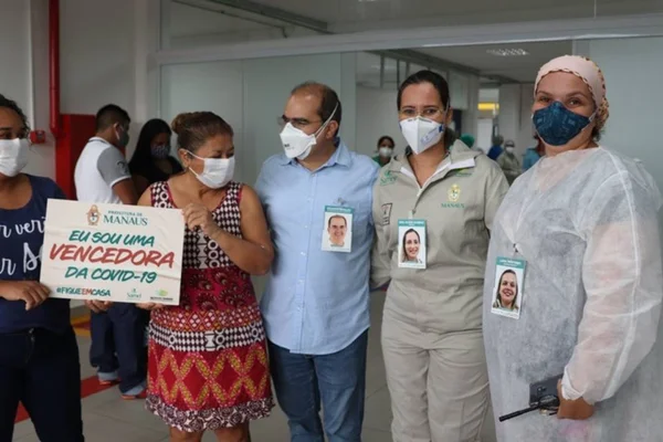 Crachás mostram sorrisos de profissionais de saúde em hospital de campanha