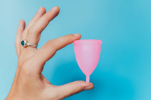 Coletor menstrual rosa em fundo azul