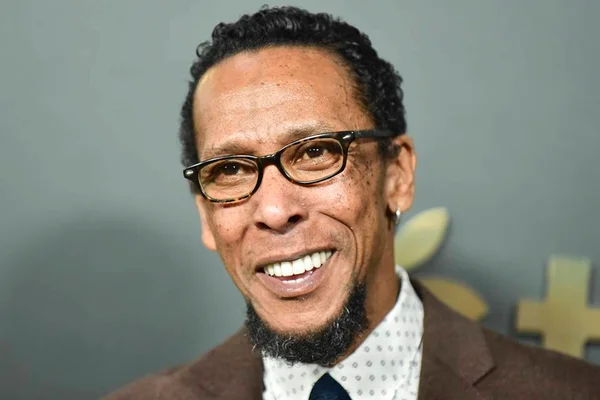 Foto colorida em close do rosto do ator Ron Cephas Jones sorrindo em um fundo cinza - Metrópoles