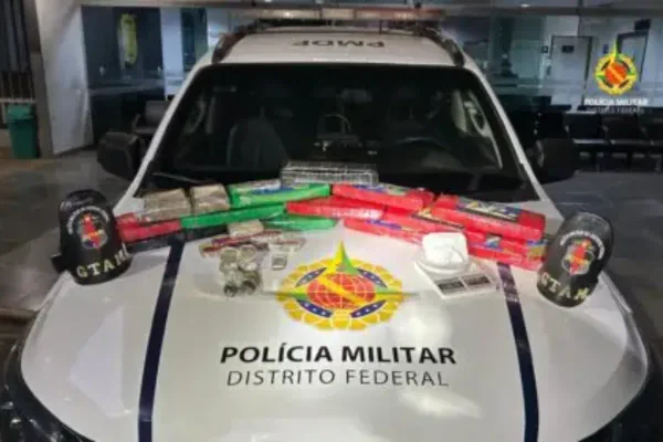 Foto colorida de viatura policial com drogas em cima