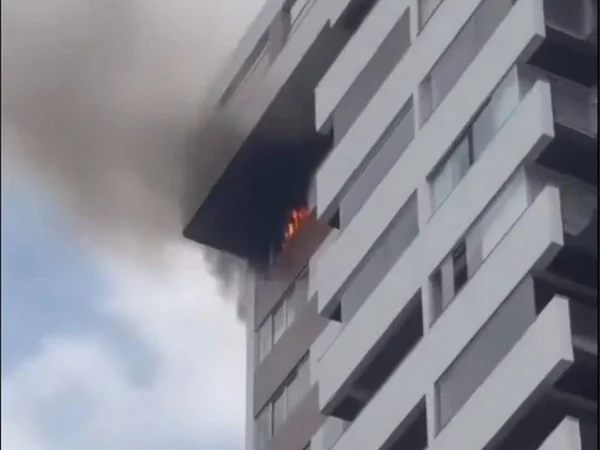 Foto colorrida de fogo saindo de janela de apartamento - Metrópoles