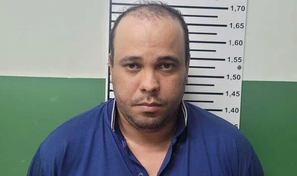 Motorista de app de blusa azul e rosto sério