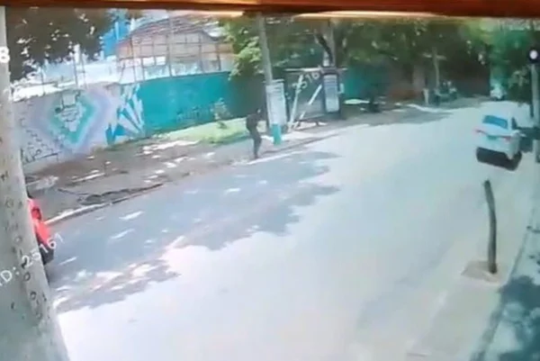 Imagem colorida de câmera de segurança mostra homem andando pela rua antes de cair ferido - Metrópoles