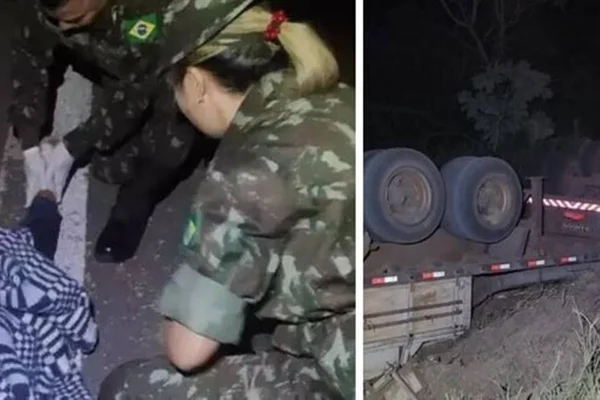 Foto colorida de motorista sendo atendido por militares após capotar caminhão - Metrópoles