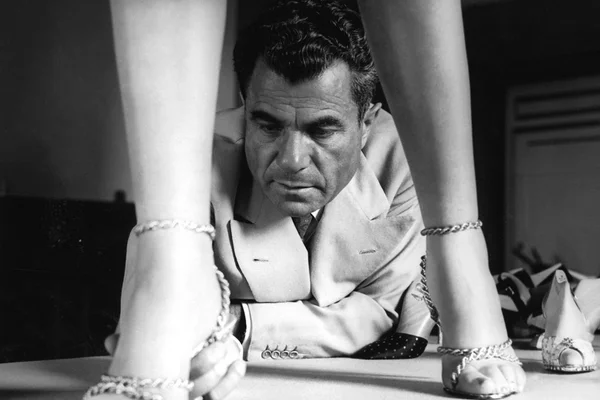 Designer Salvatore Ferragamo ajustando par de calçados