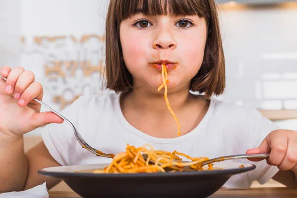 Criança comendo espaguete - Metrópoles