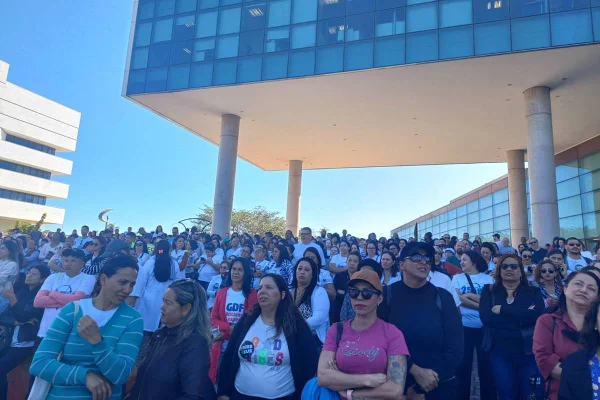 Foto colorida de manifestantes em frente ao pré