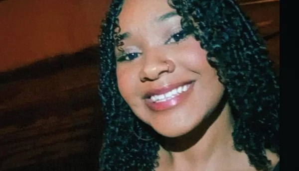 foto colorida de rostos mostra jovem morena sorrindo e olhando para a câmera