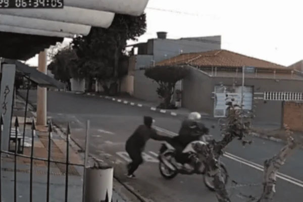 Imagem colorida de uma jovem sendo abordada por um criminoso em uma moto - Metrópoles