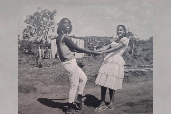 Duas amigas de mãos dadas em foto preto e branco. a imagem é uma reprodução do livro Arquivo Brasília, de Lina Kim e Michael Wesely - Metrópoles