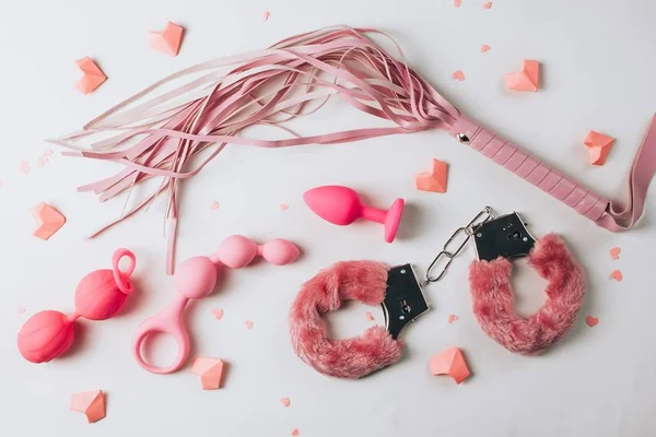 Sex toys espalhados em fundo branco - Metrópoles