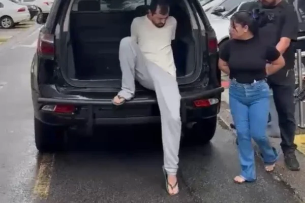 Homem com calça e camiseta claras embarca em viatura policial, pela porta traseira - Metrópoles