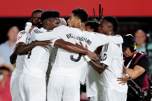 Imagem colorida dos jogadores do Real Madrid abraçados - Metrópoles