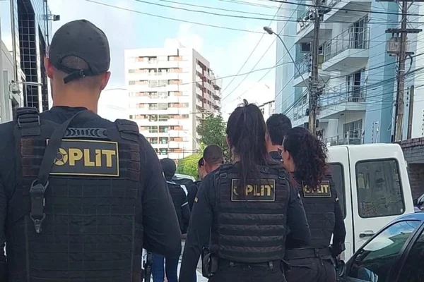 Imagem colorida mostra policiais em operação contra casal acusado de pirataria na transmissão de jogos de futebol - Metrópoles