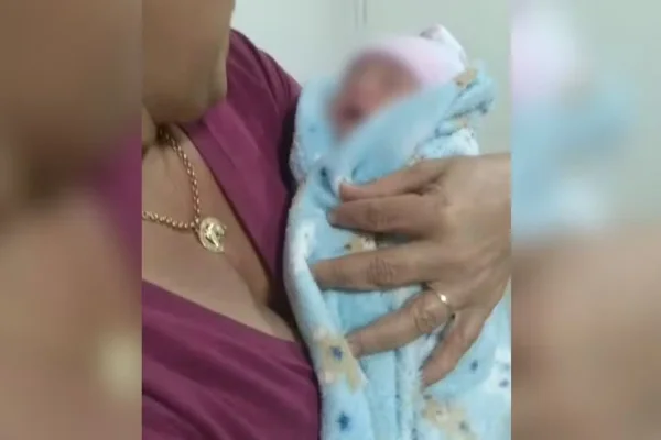Imagem colorida dde bebê raptado no colo de familiar - Metrópoles