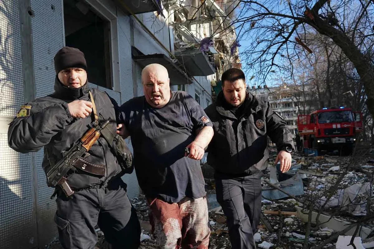 Forças de segurança ucranianas acompanham um homem ferido após um ataque aéreo atingir um complexo de apartamentos em Chuhuiv, Kharkiv Oblast, Ucrânia em 24 de fevereiro de 2022 Forças de segurança ucranianas acompanham um homem ferido após um ataque aéreo atingir um complexo de apartamentos em Chuhuiv, Kharkiv Oblast, Ucrânia em 24 de fevereiro de 2022