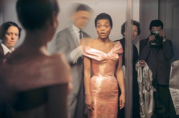 Mulher negra com vestido de festa entre pessoas / Metrópoles