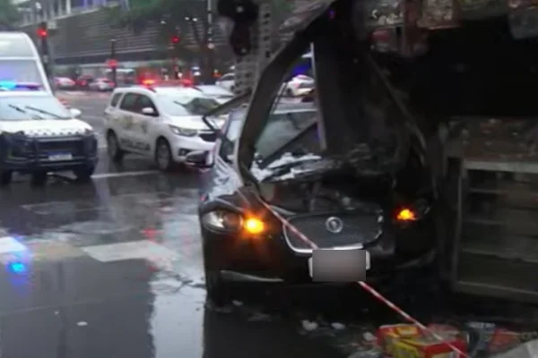 Imagem colorida de carro preto batido em banca de jornal. Metrópoles