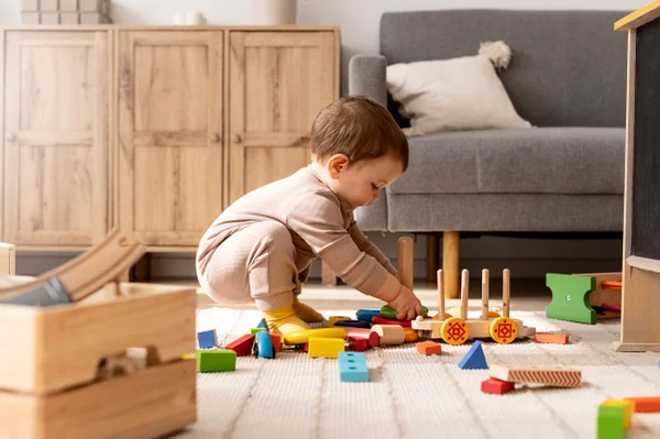 Foto colorida de bebê brincando no chão - Metrópoles