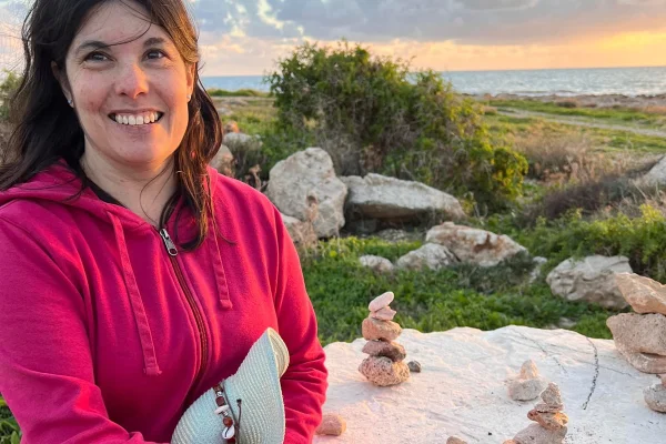 Foto colorida de mulher madura, com blusa rosa, em ambiente ao ar livre - Metrópoles.