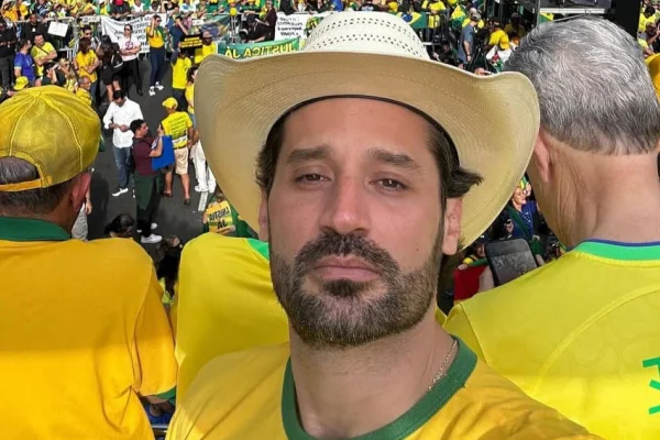 Foto colorida de Guilherme Piai, homem branco de barba, chapéu e camiseta amarela - Metrópoles