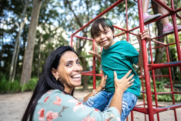Imagem colorida de mãe brincando com filho em parque. Prefeitura de SP inaugura casa para mães de pessoas com deficiência. - Metrópoles