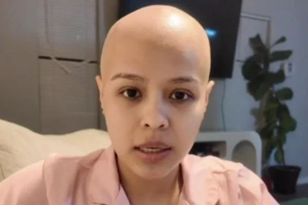 Foto colorida de mulher jovem com cabelo raspado após descoberta de cãncer - Metrópoles.
