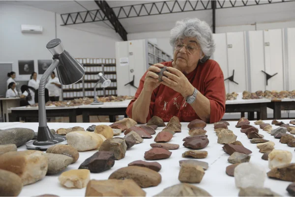Imagem colorida de uma mulher de cabelos grisalhos e vestida de laranja - Metrópoles