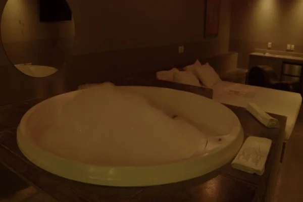 Imagem colorida mostra suíte de hotel com sauna gay. Metrópoles