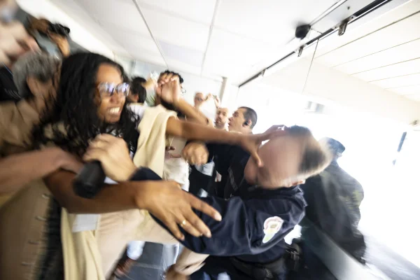 Foto colorida mostra manifestantes e guarda municipal em confronto na camara de vereadores de Porto Alegre