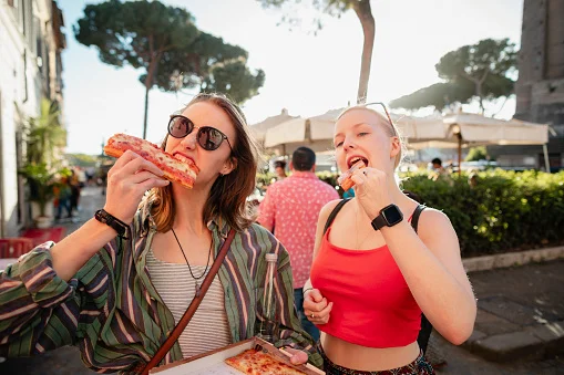 duas mulheres comendo pizza