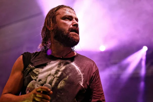 Imagem colorida de Fernando Kruscinscki cantando em show, suado - Metrópoles