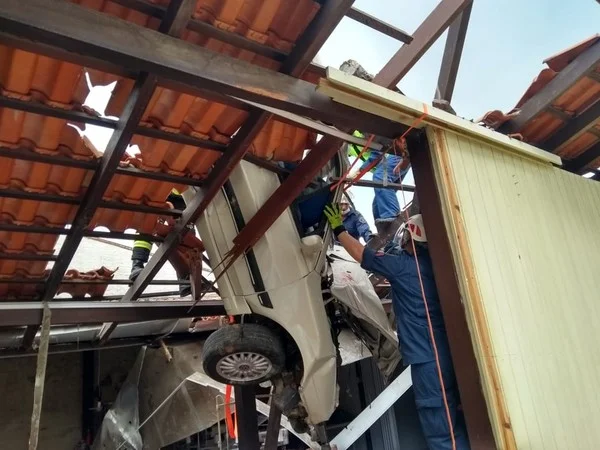 Freio do carro não funcionou e veículo acabou no telhado de confecção