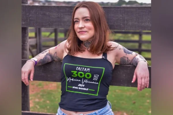 Foto de mulher encostada em cerca de madeira - Metrópoles