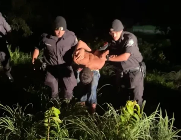Homem é levado preso por dois policiais militares