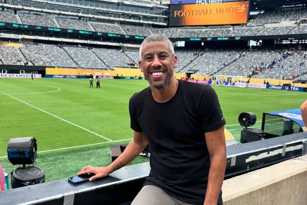 Leo Moura sentado em bancada diante de um campo de futebol