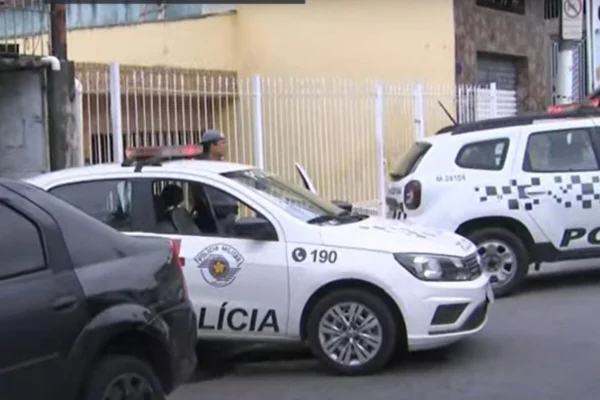 Foto colorida mostra duas viaturas da PM estacionadas em frente de residência - Metrópoles